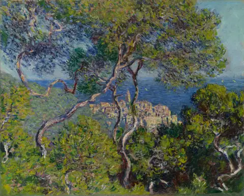 Twisting pine trees on a hillside above a blue sea and a small town.